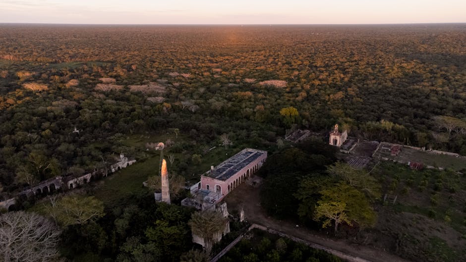 Stunning aerial shot of a historic hacienda surrounded by lush forest in Yucatán, Mexico.